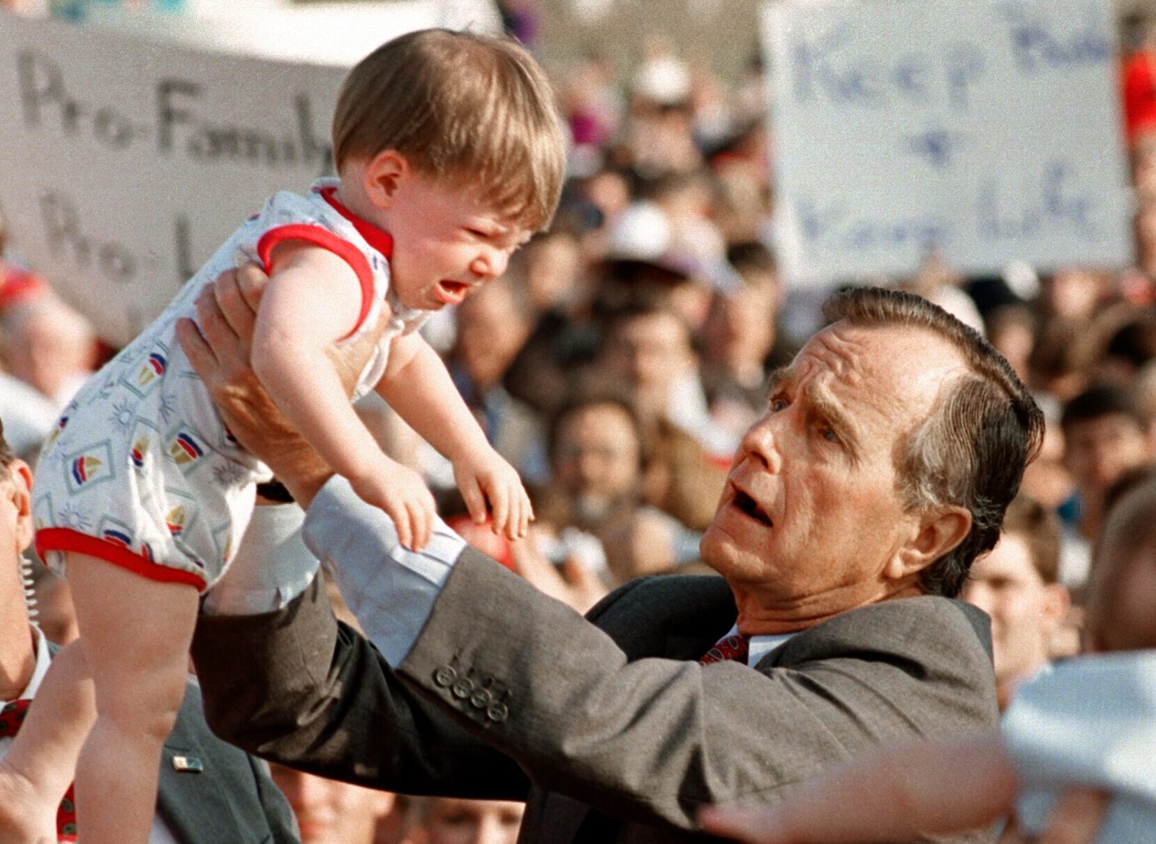 Präsident George Bush hält Baby in die Luft